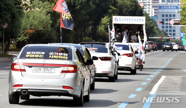 [대구=뉴시스] 이무열 기자 = 보수단체로 알려진 ‘새로운한국을위한국민운동’(새한국) 대구본부 소속 회원들이 개천절인 3일 오후 대구 수성구 황금동 어린이회관삼거리 도로에서 추미애 법무부 장관 사퇴를 촉구하는 차량 행진 집회를 하고 있다. 이들은 어린이회관삼거리, 두류네거리 등 대구 주요 도로에서 ‘추미애 법무부 장관 사퇴’ 등 문구가 적힌 깃발과 플래카드가 부착된 차량을 운행하며 추 장관 사퇴를 주장했다. 2020.10.03.lmy@newsis.com