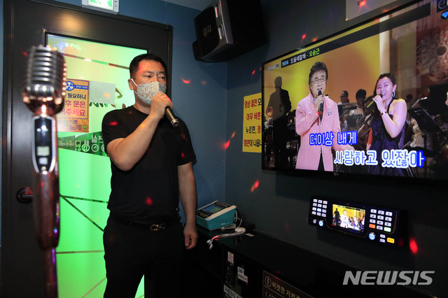 [서울=뉴시스] 박민석 기자 = 추석 연휴 마지막 날인 4일 오전 서울 서대문구 충정로에 위치한 코인노래방에서 영업주인 이방술(52)씨가 마스크를 쓰고 노래를 부르고 있다. 이씨는 "사회적 거리두기 단계가 2단계로 내려간 상황에서 술집, 공원 등은 사람들이 넘치는데 노래방과 같은 특정 업종만 단속을 하는 상황은 잘못이며, 거리두기 2단계 유지시 방역 수칙을 지키는 선에서 마스크를 쓰고라도 노래를 부를 수 있게 했으면 좋겠다"고 밝혔다. 2020.10.04.&nbsp; mspark@newsis.com