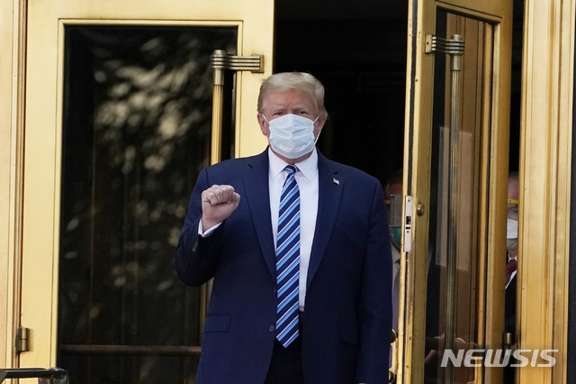 [베데스다=AP/뉴시스]도널드 트럼프 미국 대통령이 5일(현지시간) 미 메릴랜드주 베데스다의 월터 리드 국립 군 병원에서 코로나19 치료를 받은 뒤 백악관으로 돌아가기 위해 병원을 나서며 주먹을 쥐어 보이고 있다. 2020.10.06. 
