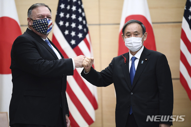[도쿄=AP/뉴시스]방일 중인 마이크 폼페이오 미국 국무장관(왼쪽)이 6일 도쿄 소재 총리 관저에서 스가 요시히데 일본 총리(오른쪽)를 접견해 마스크를 쓰고 주먹 인사를 나누고 있다. 2020.10.06.