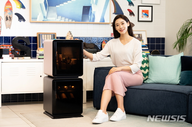 [서울=뉴시스] 삼성전자 모델이 삼성디지털프라자 강남본점 5층에 위치한 라이프스타일 쇼룸 #ProjectPRISM에서 소비자의 취향에 따라 와인, 맥주, 화장품 등을 전문적으로 보관할 수 있는 맞춤형 소형 냉장고 ‘삼성 비스포크 큐브’ 를 소개하고 있다. (제공=삼성전자)