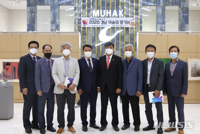 [창원=뉴시스] 홍정명 기자= 8일 ㈜무학 창원 본사 내 굿데이갤러리에서 열린 '딱! 좋은데이와 함께하는 2020 경남 미술의 향기展' 오픈식에 참석한 최재호(왼쪽 다섯 번째) 무학 회장 등이 기념촬영을 하고 있다.(사진=무학 제공) 2020.10.08. photo@newsis.com