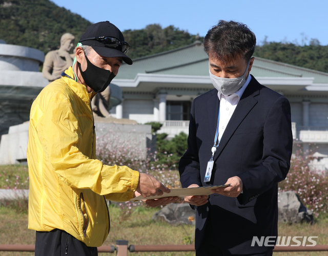 [서울=뉴시스] 조수정 기자 = 북한 피격으로 사망한 공무원 A씨 형 이래진 씨가 8일 서울 청와대 분수대 앞에서 고영호 청와대 시민사회수석 비서관실 행정관과 만나 A씨의 아들이 작성한 원본 편지를 전달하고 있다. 2020.10.08.  chocrystal@newsis.com