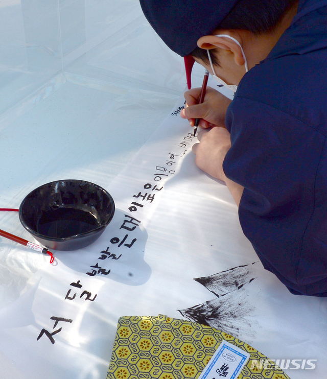 [광주=뉴시스] 김민국 기자 = 한글날인 9일 오전 광주 광산구 소촌동 용아생가에서 열린 '아시별' 한글날 행사에서 한 학생이 서예 체험을 하고 있다. 2020.10.09. blank95@newsis.com