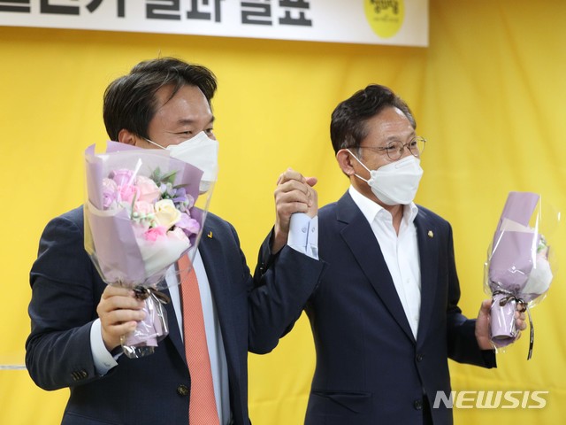 [서울=뉴시스]김선웅 기자 = 김종철 신임 정의당 대표(왼쪽)가 9일 오후 서울 여의도 정의당 중앙당사에서 열린 6기 당대표 선출선거 결과 발표에서 낙선한 배진교 후보와 손을 맞잡고 있다. (공동취재사진) 2020.10.09.&nbsp; photo@newsis.com