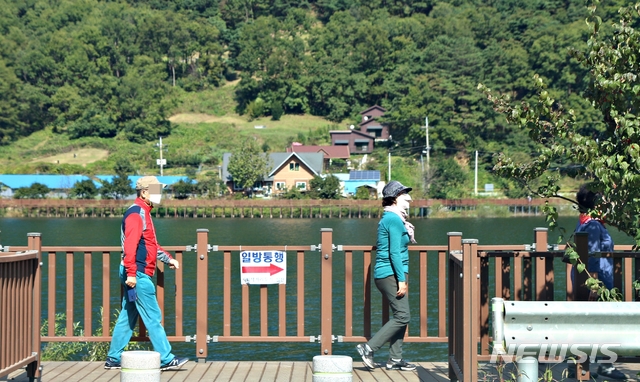 [증평=뉴시스]강신욱 기자 = 주말인 10일 충북 증평군 증평읍 율리 삼기저수지 등잔길 데크로드에 가을 정취를 느끼려는 사람들의 발길이 이어지고 있다. 신종 코로나바이러스 감염증(코로나19) 사회적 거리두기에 따라 방문객들이 일정 거리를 두고 한 방향으로 걷고 있다. 2020.10.10.&nbsp; ksw64@newsis.com 