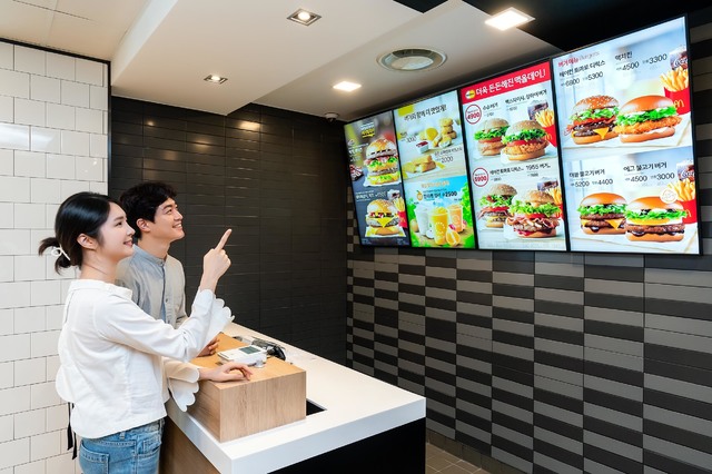 [서울=뉴시스]삼성전자 모델이 경기도 고양시에 위치한 맥도날드 고양삼송DT점에 설치된 삼성 스마트 사이니지를 소개하고 있다. 사진 삼성전자 