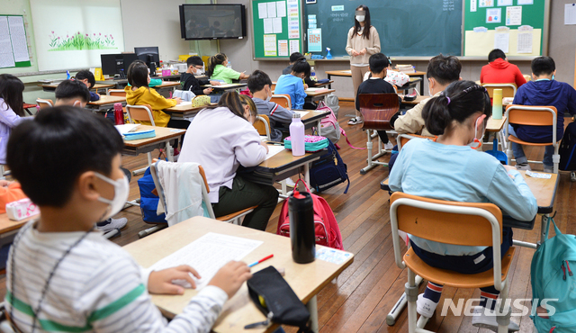 [광주=뉴시스] 김민국 기자 = 사회적 거리두기가 1단계로 완화된 12일 오전 광주 광산구 소촌동 모 초등학교 교실에서 초등생들이 거리를 둔 채 앉아있다. 2020.10.12.   blank95@newsis.com