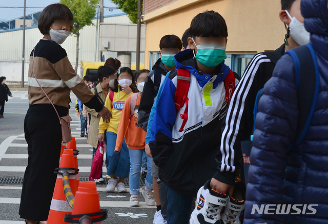 [광주=뉴시스] 김민국 기자 = 사회적 거리두기가 1단계로 완화된 12일 오전 광주 광산구 소촌동 모 초등학교에서 초등생들이 일렬로 등교하고 있다. 2020.10.12.  blank95@newsis.com