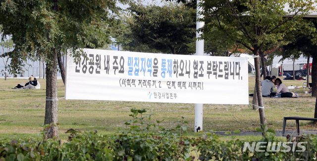 [서울=뉴시스]최진석 기자 = 12일 전국 사회적 거리두기 단계가 2단계에서 1단계로 완화되며 통제가 해제된 서울 영등포구 여의도 한강공원 이벤트광장에서 시민들이 휴식을 취하고 있다. 2020.10.12. myjs@newsis.com