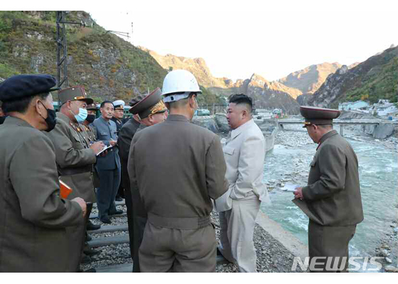 [서울=뉴시스] 김정은 북한 국무위원장이 지난달 태풍피해를 크게 입은 함경남도 검덕 지구 복구현장을 방문해 철길 위에서 군인들에게 복구방향을 지시하고 있다. 철길다리 한쪽에 선 김정은을 보면서 옆에 있는 한 군인이 불안하다는 듯이 다리 아래쪽을 바라보고 있다. (출처=노동신문) 2020.10.14.