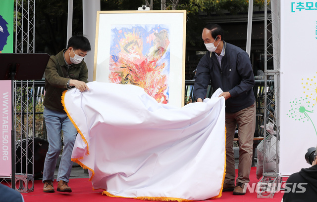 [서울=뉴시스] 이영환 기자 = 이수호(오른쪽) 전태일재단 이사장이 14일 오전 서울 종로구 전태일다리에서 열린 전태일 50주기 '전태일 추모의 달' 선포식에서 후랭키 화백의 헌정 그림을 공개하고 있다. 2020.10.14. 20hwan@newsis.com