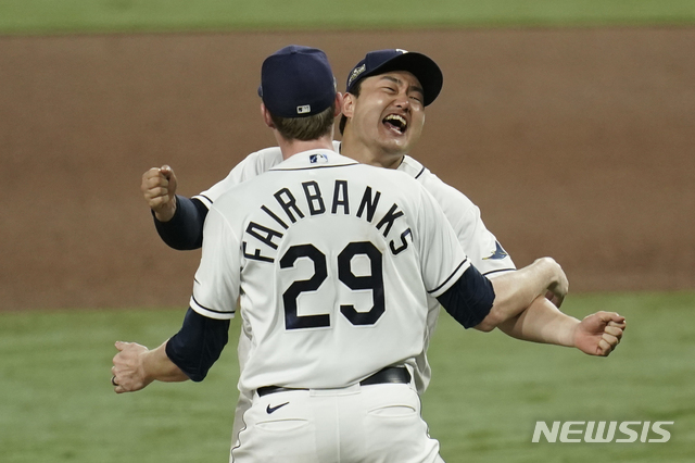 Tampa Bay Rays pitcher Peter Fairbanks and Ji-Man Choi celebrate their victory against the Houston Astros in Game 7 of a baseball American League Championship Series, Saturday, Oct. 17, 2020, in San Diego. The Rays defeated the Astros 4-2 to win the series 4-3 games. (AP Photo/Gregory Bull)