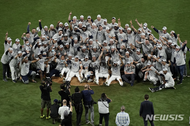 Tampa Bay Rays pose with the American League championship trophy following their victory against the Houston Astros in Game 7 of a baseball American League Championship Series, Saturday, Oct. 17, 2020, in San Diego. The Rays defeated the Astros 4-2 to win the series 4-3 games. (AP Photo/Jae C. Hong)