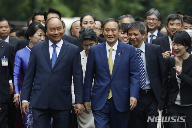 [하노이=AP/뉴시스]19일 베트남 하노이 소재 대통령궁에서 응우옌 쑤언 푹 베트남 총리(왼쪽)와 스가 요시히데 일본 총리(오른쪽)가 함께 걷고 있다. 양 측은 이날 오전 회담을 가졌다. 2020.10.19. 