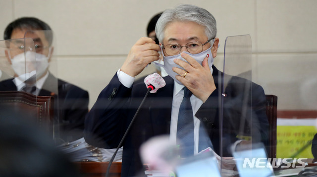 [서울=뉴시스] 최동준 기자 = 김용익 국민건강보험공단 이사장이 20일 서울 여의도 국회에서 열린 보건복지위원회의 국민건강보험공단, 건강보험심사평가원에 대한 국정감사에서 마스크를 고쳐쓰고 있다. (공동취재사진) 2020.10.20.&nbsp; photo@newsis.com