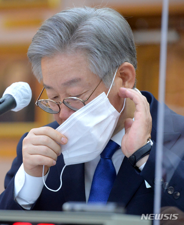 [수원=뉴시스]사진공동취재단 = 이재명 경기도지사가 20일 경기도 수원시 팔달구 경기도청에서 열린 국회 국토교통위원회의 경기도에 대한 국정감사에서 마스크를 고쳐쓰고 있다. 2020.10.20.&nbsp; photo@newsis.com