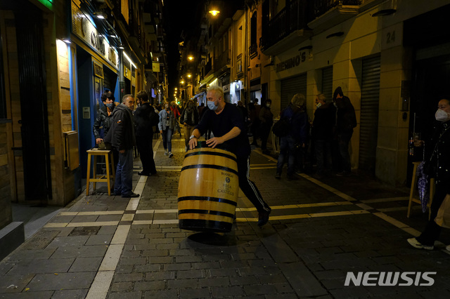 [팜플로나=AP/뉴시스]21일(현지시간) 스페인 북부 팜플로나에서 코로나19 새 규제에 따라 모든 술집과 식당이 향후 2주간 오후 11시부터 문을 닫게되면서 한 남성이 술집 문을 닫을 준비를 하고 있다. 스페인은 이날 코로나19 신규 감염자 1만6973명이 발생, 서유럽 국가 중 최초로 코로나19 감염자 수가 100만 명을 넘어섰다. 2020.10.22.