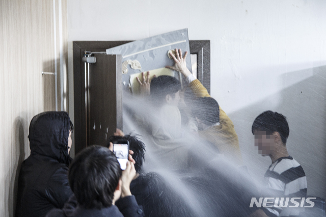 [서울=뉴시스] 지난 2017년 서울대의 '시흥 캠퍼스 실시 협약' 체결에 반발하며 본부 점거 투쟁을 벌인 서울대 학생들에게 교직원들이 소화기를 이용해 물을 뿌리는 모습. (사진 = 서울대 인권위 진정 사건 대표 진정인단)