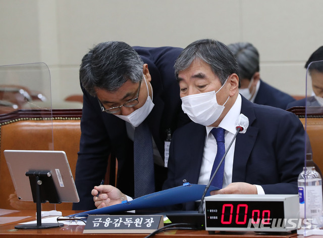 [서울=뉴시스] 최동준 기자 = 윤석헌 금융감독원 원장이 23일 서울 여의도 국회에서 열린 정무위원회의 금융감독원, 금융위원회 등에 대한 종합감사에서 관계자와 대화하고 있다. (공동취재사진) 2020.10.23. photo@newsis.com