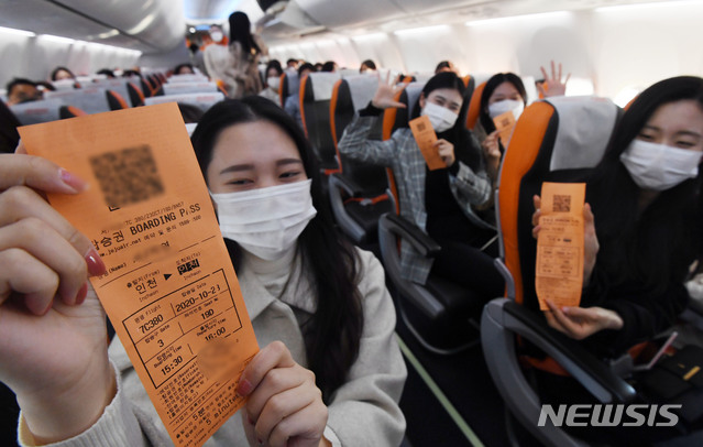[인천공항=뉴시스] 공항사진기자단 = 제주항공 ‘인천 to 인천’ 관광비행 승객들이 23일 인천국제공항 1터미널에서 B737-800NG 항공기에 탑승해 이륙하기 전 항공권을 보이며 즐거워하고 있다. 이날 제주항공은 일반인을 대상으로 국내 상공을 선회한 뒤 복귀하는 관광비행을 진행했다. 2020.10.23. photo@newsis.com