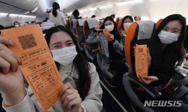 [인천공항=뉴시스] 공항사진기자단 = 제주항공 ‘인천 to 인천’ 관광비행 승객들이 23일 인천국제공항 1터미널에서 B737-800NG 항공기에 탑승해 이륙하기 전 항공권을 보이며 즐거워하고 있다. 이날 제주항공은 일반인을 대상으로 국내 상공을 선회한 뒤 복귀하는 관광비행을 진행했다. 2020.10.23. photo@newsis.com