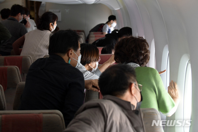 [제주=뉴시스] 공항사진기자단 = 24일 인천국제공항을 출발한 아시아나항공 'A380 한반도 일주 비행 항공기'에서 승객들이 한라산 백록담을 바라보고 있다. 승객 250명을 태우고 오전 11시께 인천국제공항을 이륙한 'A380 한반도 일주 비행 항공기'는 동해바다가 보이는 강릉, 한라산 백록담이 보이는 제주도를 지나 오후 1시 20분께 인천국제공항으로 돌아오는 특별 관광 상품이다. 2020.10.24. photo@newsis.com