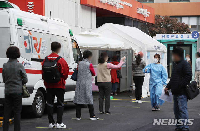 [서울=뉴시스] 조수정 기자 = 26일 오전 서울 중구 국립중앙의료원 코로나19 선별진료소에서 시민과 출국예정자들이 검사를 받기 위해 줄서 기다리고 있다. 2020.10.26.  chocrystal@newsis.com