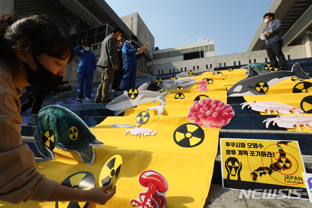 [서울=뉴시스] 조수정 기자 = 환경운동연합 바다위원회 회원들이 일본 정부의 후쿠시마 핵발전소 방사성 오염수 처리 여부 결정을 하루 앞둔 26일 오전 서울 종로구 세종문화회관 계단에서 방사성 물질을 상징하는 노란 천을 깔아놓고 오염수 방류 계획 규탄 기자회견을 준비하고 있다. 2020.10.26.  chocrystal@newsis.com