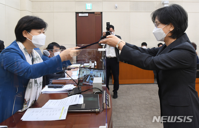 [서울=뉴시스]김선웅 기자 = 노정희 중앙선거관리위원 후보자(오른쪽)가 27일 서울 여의도 국회에서 열린 인사청문회에 출석해 선서 후 서영교 행안위원장에게 선서문을 제출하고 있다.&nbsp; 김명수 대법원장이 지명한 노 후보자는 현재 대법관으로, 서울고등법원 부장판사, 법원도서관장 등을 지냈다. 현재 공석인 중앙선관위원장은 선관위원 중 대법관을 호선해 임명하는 것이 관례로, 노 후보자가 청문회를 통과할 경우 최초의 여성 중앙선관위원장이 된다. (공동취재사진) 2020.10.27&nbsp; photo@newsis.com