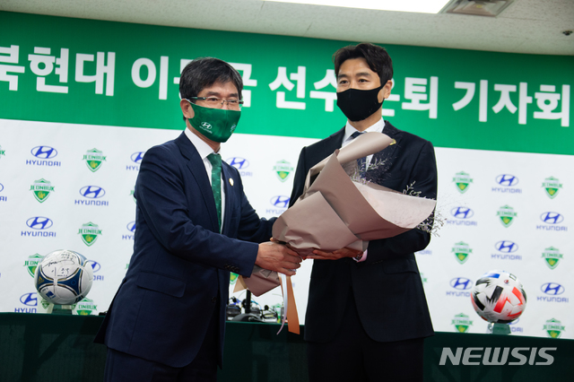 [서울=뉴시스] K리그의 살아있는 전설 이동국(41·전북)이 은퇴 기자회견에서 백승권 단장에게 꽃다발을 받고 있다. (사진=전북 현대 제공)