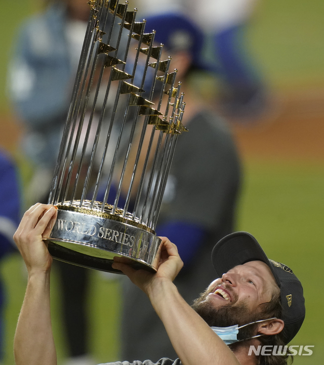 [알링턴=AP/뉴시스]LA 다저스 투수 클레이튼 커쇼가 27일(현지시간) 미 텍사스주 알링턴의 글로브 라이프 필드에서 막을 내린 탬파베이 레이스와의 월드시리즈 6차전을 3-1로 이긴 후 월드시리즈 우승컵을 들고 환히 웃고 있다. 다저스는 통산 전적 4승 2패로 1988년 이후 32년 만에 월드시리즈 우승을 차지했다. 2020.10.28. 