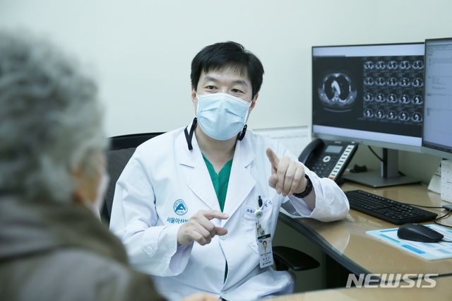 [서울=뉴시스] 서울아산병원 호흡기내과 최창민 교수가 80대 조기 폐암 여성 환자를 진료하고 있다. (사진= 서울아산병원 제공) photo@newsis.com 