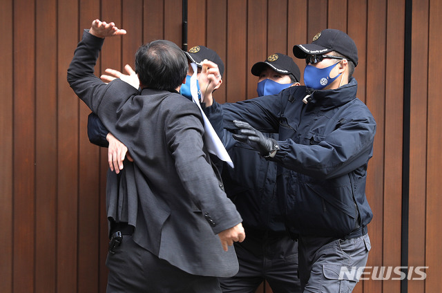 [서울=뉴시스] 김병문 기자 = 회사 자금을 횡령하고 삼성 등에서 거액의 뇌물을 챙긴 혐의로 재판에 넘겨진 이명박 전 대통령의 대법원 선고일인 29일 서울 강남구 논현동 자택 앞에서 한 유튜버가 이 전 대통령의 대국민 사과를 촉구하며 문을 두드리자 경호병력들이 제지하고 있다. (공동취재사진) 2020.10.29.&nbsp; photo@newsis.com 