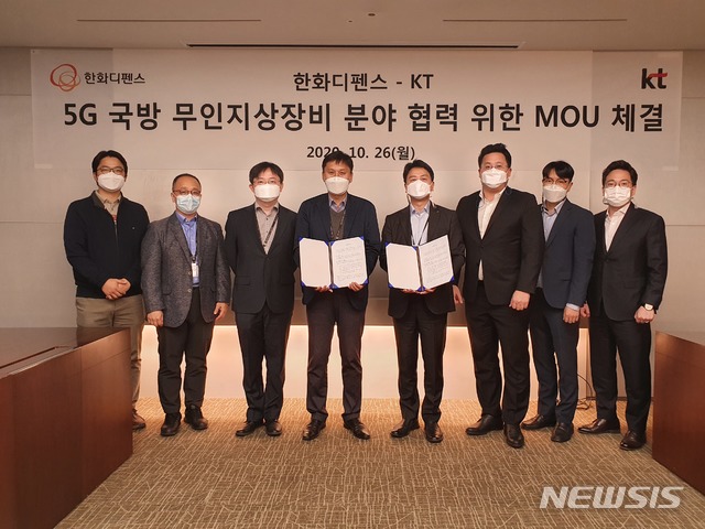 [서울=뉴시스]한화디펜스 미래기술센터장 김태형 상무(좌측 4번째)와 KT 기업사업전략본부 융합사업개발담당 이대형 상무 및 양사 관계자들이 지난 26일 한화디펜스 판교 R&D 센터에서 5G 국방 무인지상장비 분야 협력 양해각서를 체결하고 기념사진을 찍고 있다. 2020.10.30 (사진 = 한화디펜스 제공) photo@newsis.com