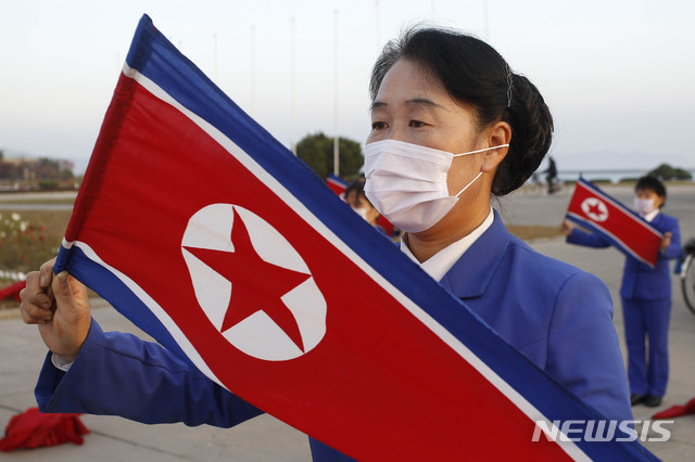 [원산=AP/뉴시스]러시아의 농장이 북한 노동자 50명을 ‘학생 연수생’ 신분으로 위장해 고용하기 위한 계약을 체결했다고 NK뉴스가 20일(현지 시간) 보도했다. 사진은 2020년 10월 28일 북한 강원도 원산의 해안광장 앞에서 인공기를 든 원산시 여성노동조합원들이 출근 시간대 노동자들을 격려하기 위한 선동 활동을 하고 있는 모습. 2026.08.21.
