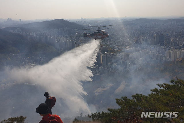 [서울=뉴시스]이윤청 기자 = 30일 서울 은평구 북한산 족두리봉 인근에서 산불이 나 소방헬기가 진화작업을 하고 있다. (사진=소방청 제공) 2020.10.30. photo@newsis.com