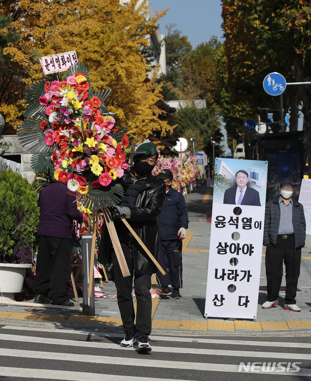 [서울=뉴시스] 박미소 기자 = 보수단체 회원들이 윤석열 검찰총장 지지자들이 보낸 수백개의 대검찰청(대검) 앞 화환을 2일 오전 서울 서초구 대검찰청 앞에서 자진 철거하고 있다.2020.11.02.  misocamera@newsis.com