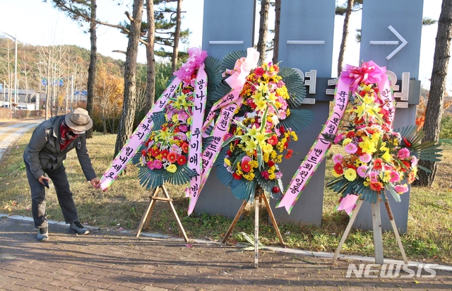 [진천=뉴시스]강신욱 기자 = 3일 오후 윤석열 검찰총장이 신임 부장검사들을 대상으로 교육하기 위해 방문하는 충북 진천군 법무연수원 입구에는 윤석열(포청천)밴드회원 일동으로 윤석열 총장과 한동훈 검사를 응원하고 추미애 법무부장관을 비난하는 화환이 놓여 있다. 한 회원이 바람에 날리는 화환을 정리하고 있다. 2020.11.03.  ksw64@newsis.com 