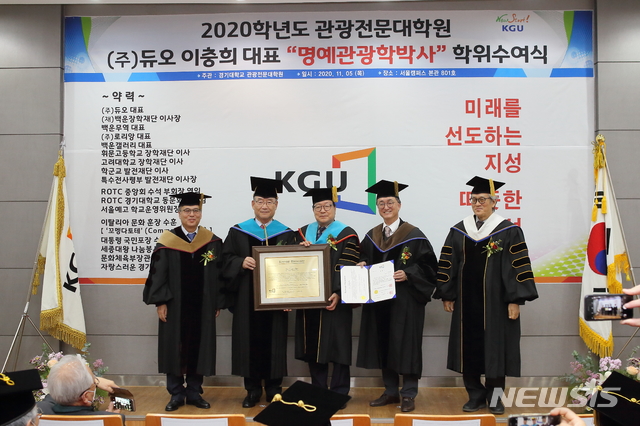 [수원=뉴시스] 5일 오후 경기대학교 서울캠퍼스에서 열린 명예관광학 박사 수여식 행사에서 ㈜듀오 이충희 대표이사가 경기대 김인규 총장으로부터 명예관광학 박사 학위를 받고 있다. (사진=경기대학교 제공)