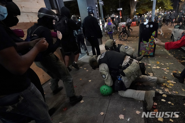 [포틀랜드=AP/뉴시스]도널드 트럼프 미국 대통령이 일부 경합 주에 대해 개표 중단 소송을 제기한 가운데 4일(현지시간) 미 오리건주 포틀랜드에서 오리건주 경찰이 시위하던 한 남성을 체포하고 있다. 2020.11.05.