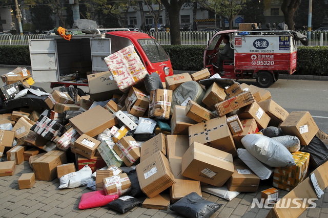 [베이징=AP/뉴시스]2020년 11월 11일 중국 베이징의 한 아파트 인근 픽업 지점에 한 택배 차량이 내려놓은 택배 물품이 쌓여 있는 모습.