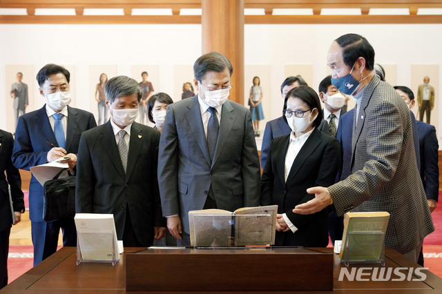 [서울=뉴시스]박영태 기자 = 문재인 대통령과 전태일 열사 유가족이 12일 청와대 본관에서 열린 전태일 열사 훈장 추서식 후 환담장으로 이동하며 로비에 전시된 전태일 평전 및 태일실업 설립 계획서를 보며 이야기를 나누고 있다. 2020.11.12. since1999@newsis.com