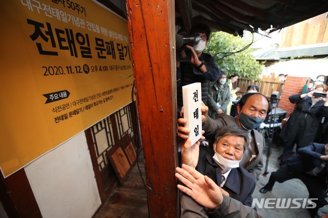 [대구=뉴시스] 이무열 기자 = 대구 출신의 노동운동가 전태일(1948~1970) 열사 50주기를 하루 앞둔 12일 오후 대구 중구 남산동 2178-1번지 한옥에서 사단법인 '전태일의 친구들' 주최로 열린 전태일 문패 달기 행사에서 참석자 대표가 문패를 달고 있다. lmy@newsis.com