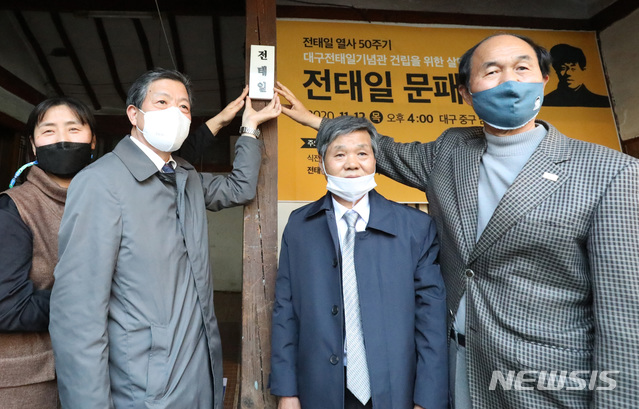 [대구=뉴시스] 이무열 기자 = 대구 출신의 노동운동가 전태일(1948~1970) 열사 50주기를 하루 앞둔 12일 오후 대구 중구 남산동 2178-1번지 한옥에서 사단법인 '전태일의 친구들' 주최로 열린 전태일 문패 달기 행사에서 참석자 대표가 문패를 달고 있다. 왼쪽부터 시민모금운동 참여 시민대표 서춘희씨, 사단법인 전태일의 친구들 이재동 이사장, 전태일 열사 동생 전태삼씨, 이수호 전태일재단 이사장.lmy@newsis.com