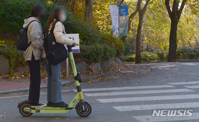 [광주=뉴시스] 김민국 기자 = 지난 12일 오후 광주 북구 용봉동 한 캠퍼스에서 2명의 이용객이 한 대의 전동 킥보드를 탄 채 달리고 있다. 2020.11.15. blank95@newsis.com <사진은 기사 내용과 직접 관련 없습니다.>