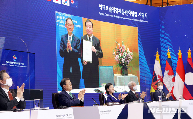 [서울=뉴시스]박영태 기자 = 문재인 대통령이 15일 청와대 본관에서 화상회의로 열린 역내포괄적경제동반자협정(RCEP) 정상회의 및 협정 서명식에 참석해 일본의 서명식을 본 후 박수치고 있다. 문 대통령 뒤 모니터에 스가 요시히데 총리가 보이고 있다. 2020.11.15.&nbsp; since1999@newsis.com