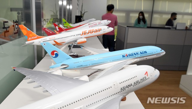 [서울=뉴시스]이영환 기자 = 정부와 산업은행이 대한항공의 아시아나항공 인수를 공식화한 16일 오전 서울 강서구 한국민간항공조종사협회에서 대한항공과 아시아나항공 노동조합 관계자들이 모여 대책을 논의하기전 한 직원이 양 항공사 모형 비행기 앞을 지나고 있다. (사진=공동취재사진) 2020.11.16. photo@newsis.com