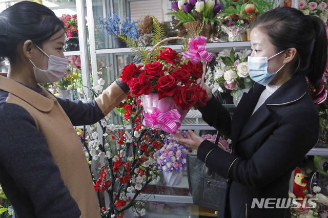 [평양=AP/뉴시스]16일 북한 평양의 한 꽃집에서 한 여성이 어머니날을 맞아 꽃을 사고 있다. 북한은 2012년 5월 최고인민회의 상임위원회에서 매년 11월 16일을 어머니날로 제정했다. 2020.11.17.