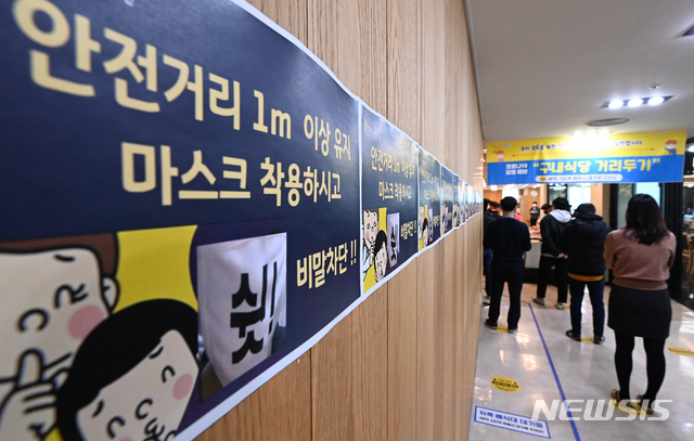 [수원=뉴시스] 김종택기자 = 정부가 신종코로나바이러스 감염증(코로나19) 확진자가 급격히 늘고 있는 수도권 지역을 대상으로 '사회적 거리두기 1.5단계' 격상을 발표한 17일 경기도 수원시청 구내식당에서 직원들이 거리두기를 유지하며 배식을 기다리고 있다. 2020.11.17. jtk@newsis.com